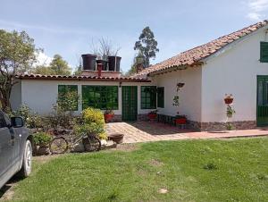 een huis met een auto ervoor geparkeerd bij Alojamiento Rural San Antonio in Ubaté