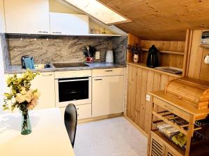 a kitchen with a table with a vase of flowers at Chesa Margadant in Zuoz
