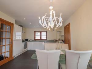 uma cozinha com uma mesa de jantar e um lustre em Lossiemouth Bay Cottage em Lossiemouth