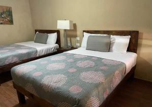 a hotel room with two beds and a lamp at Hotel Casa Puerta Huasteca in Ciudad Valles