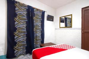 1 dormitorio con 1 cama y una pared colorida en OYO Hotel Brazil,Guadalajara,Estadio Jalisco, en Guadalajara