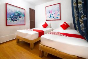 2 camas con almohadas rojas en una habitación en OYO Hotel Brazil,Guadalajara,Estadio Jalisco, en Guadalajara