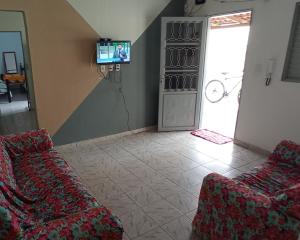 ein Wohnzimmer mit 2 Sofas und einem TV in der Unterkunft Casa do Bueno in Teresina de Goias