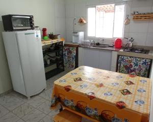 eine Küche mit einem Tisch und einem Kühlschrank in der Unterkunft Casa do Bueno in Teresina de Goias