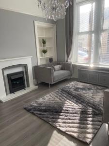 a living room with a couch and a fireplace at The Princess Flat, Helensburgh. in Helensburgh