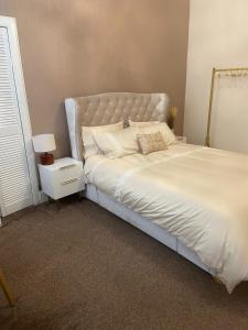 een slaapkamer met een groot bed met een wit bedframe bij The Princess Flat, Helensburgh. in Helensburgh