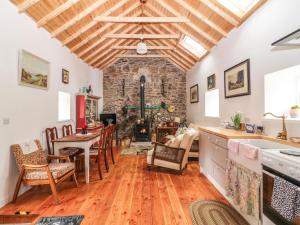 een keuken met een tafel en stoelen en een stenen open haard bij The Dairy in Clonmel