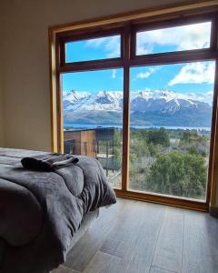 a bedroom with a large window with a view of mountains at Lomas Schuss ARG41 in San Carlos de Bariloche