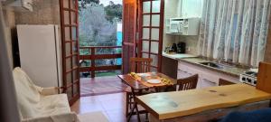 a kitchen with a table and a refrigerator and a table at Do Sonho a Realizacao in Monte Verde