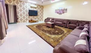 a living room with a couch and a tv at شالية البندرvip in Ḩifrī