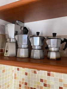 a shelf with three pots and pans on it at Villa Ginevri, La casa vacanze immersa nel verde in Mondavio