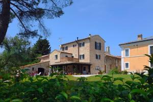a large stone building in a field of grass at Villa Ginevri, La casa vacanze immersa nel verde in Mondavio