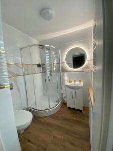 a bathroom with a shower and a toilet and a sink at Amonit in Olsztyn