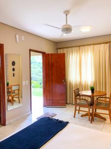 ein Wohnzimmer mit einem Tisch und einem Esszimmer in der Unterkunft O Recanto Pousada in Serra Negra