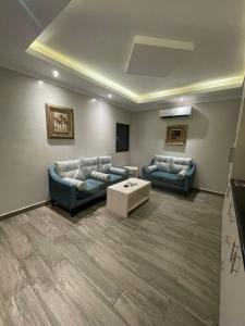 uma sala de estar com dois sofás e uma mesa de centro em Rose Neri Lavender روز نيري الخزامى em Al Khobar