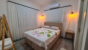 een kleine slaapkamer met een bed met een witte deken bij Villa Koyuncu in Dalaman