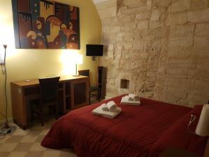 a bedroom with a red bed with towels on it at B&B Residenza Pizziniaco in Lecce