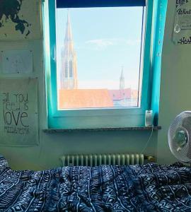 una camera da letto con finestra affacciata su un edificio di Helle, grosse, zentrale Wohnung mit Balkon a Monaco