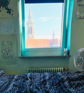 a bedroom with a window with a view of a building at Helle, grosse, zentrale Wohnung mit Balkon in Munich