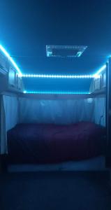 a room with a bed with blue lights on it at Cara Noir in Inverness