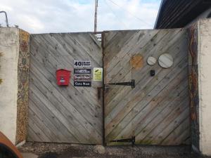 a wooden gate with two signs on it at Cara Noir in Inverness