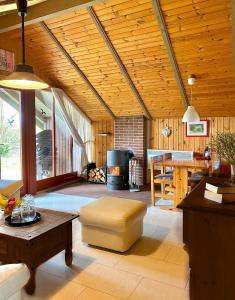 ein Wohnzimmer mit einer Holzdecke und einem Tisch in der Unterkunft Ferienhäuser Pannier I und oder II in Gartow
