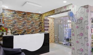 a lobby with a white counter and a brick wall at Itsy By Treebo - Raj Resort, Calangute in Calangute