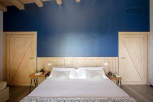 a bedroom with a large bed with a blue wall at I Carusi Relais in Noto
