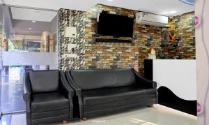 une salle d'attente avec 2 fauteuils en cuir et une télévision à écran plat dans l'établissement Itsy By Treebo - Raj Resort, Calangute, à Calangute