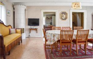 - une salle à manger avec une table, des chaises et une télévision dans l'établissement 3 Bedroom Beautiful Home In Ronneby, à Ronneby