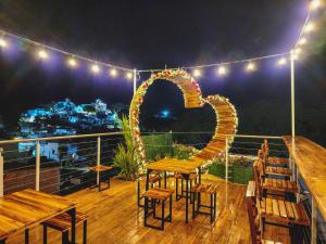 a table and chairs on a deck with lights at MIRADORES DEL PARAISO in Doradal