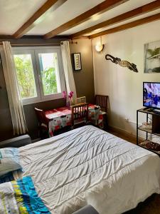 um quarto com uma cama, uma mesa e uma janela em charmante maison em Sainte-Marie