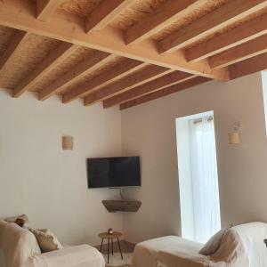ein Wohnzimmer mit Holzdecken und einem Flachbild-TV in der Unterkunft Cottage chaleureux dans un Domaine d'exception in Nomdieu