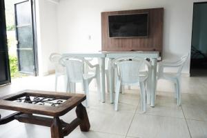 une table à manger blanche avec des chaises blanches et une télévision dans l'établissement Casa Quinta Villa Carolita, à Melgar