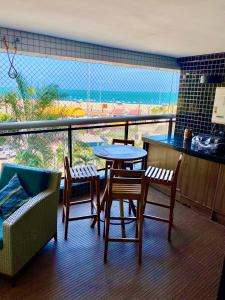 a balcony with a table and chairs and a view of the ocean at Landscape Beira Mar Deluxe Vista Mar in Fortaleza