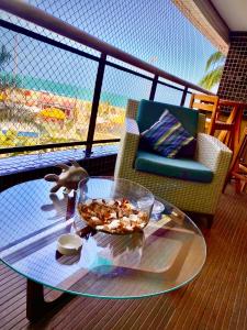 einen Glastisch mit einer Schale Nüsse auf dem Balkon in der Unterkunft Landscape Beira Mar Deluxe Vista Mar in Fortaleza