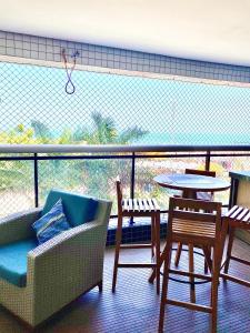 a balcony with a chair and a table and a table and chairs at Landscape Beira Mar Deluxe Vista Mar in Fortaleza