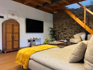 um quarto com uma cama e uma televisão na parede em Rural Lambre by Miramar Stays em La Coruña