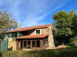 a stone house with a red roof at Rural Lambre by Miramar Stays in A Coruña