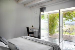 a bedroom with a bed and a balcony with a desk at I Carusi Relais in Noto