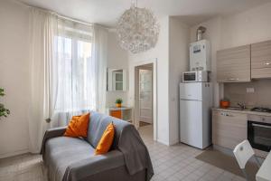 a living room with a couch and a kitchen at Appartamento vicino Ospedale con self check-in in Parma