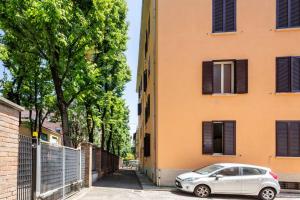 una macchina argentata parcheggiata di fronte a un edificio di Appartamento vicino Ospedale con self check-in a Parma