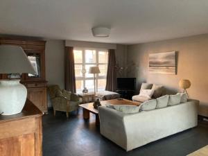 a living room with a couch and a table at Agréable et Spacieuse maison centre ville Saint-Omer in Saint-Omer