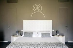 a bedroom with a large white bed with two pillows at I Carusi Relais in Noto