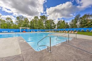 a large swimming pool with chairs and a blue wall at Cozy Cassopolis Retreat on Little Fish Lake! in Cassopolis