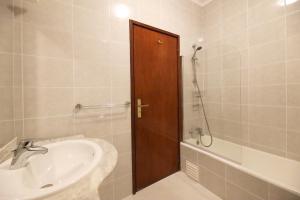 a bathroom with a sink and a wooden door at FLH Porto Classic Design with Terrace in Porto