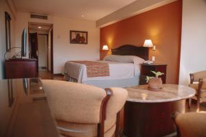 a hotel room with a bed and a table and chairs at Casa Real Hotel in Salta