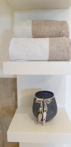 - une étagère blanche avec un bol et des serviettes dans l'établissement Ferienwohnung Jehl, à Aying 17 autres photos