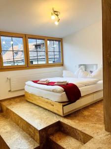 una camera con un grande letto su una piattaforma di legno di Chesa Margadant a Zuoz