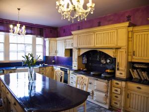 a kitchen with wooden cabinets and a black counter top at Boothorpe Hall in Swadlincote
